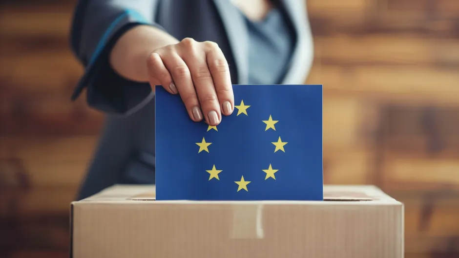 KI-generiertes Bild: Person wirft "Wahlschein" in eine Wahlurne, der Schein ist dunkelblau mit gelbem EU-Sternenkreis ist